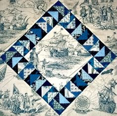 a blue and white quilt with an image of people on boats in the water below it