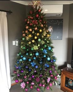 a christmas tree is decorated with colorful ornaments