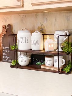 a kitchen shelf filled with white dishes and mugs