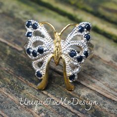 Handmade, Natural Blue Sapphire Butterfly Sterling Silver, 14k Yellow Gold Ring Size 7.5 🦋Featured in this listing is a sterling silver, handmade, natural stone ring.  This lovely handmade ring features a beautiful, Natural Blue Sapphire  stones that have been set within a large butterfly. Each round faceted Blue Sapphire gemstones has been prong set into highly polished Sterling Silver with 14k gold accents throughout highly detailed ring.  🦋Made with 100% Natural gemstones, with a statement Elegant Blue Sterling Silver Butterfly Ring, Gold Sterling Silver Butterfly Ring, Gold Sterling Silver Butterfly Ring For Anniversary, Blue Sterling Silver Jewelry Stamped 14k, Silver Sapphire Ring For Jewelry Making, Sapphire Jewelry Stamped 14k For Gift, Handmade Sterling Silver Butterfly Ring For Anniversary, Gemstone Butterfly Ring For Anniversary, Silver Sterling Sapphire Ring For Anniversary