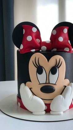 a mickey mouse cake with red and white polka dots on it's head, sitting on a table