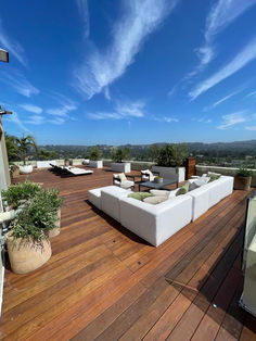 a wooden deck with white couches on it