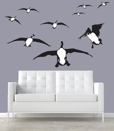 a living room with a white couch and black birds on it's wall decals