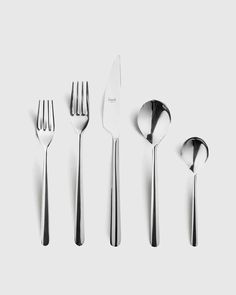 four forks, two spoons and one knife on a white surface