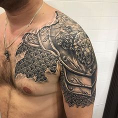 a man's chest is covered in black and white tattoos, with a lion on it