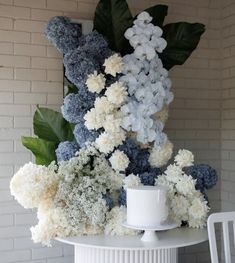 a white table topped with a cup and flowers