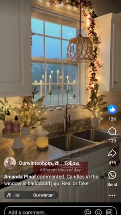 a kitchen decorated for christmas with candles in the window and garland on the windowsill