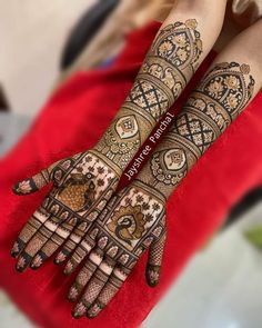 a woman's hands with henna tattoos on them