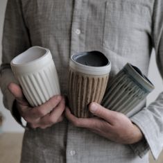 a man holding two coffee cups in his hands