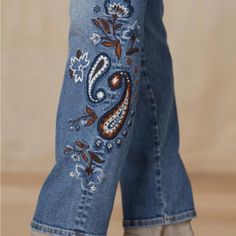 a pair of jeans with embroidered designs on them