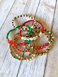 three bracelets with beads and merry written on them sitting on a wooden floor next to each other