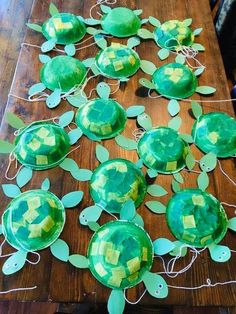 some paper plates with turtles on them sitting on top of a wooden table next to string