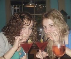 two women sitting at a table with drinks