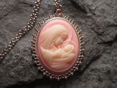 "Wonderful look for Easter and Christmas!! Beautiful Virgin Mary cradling baby Jesus cameo necklaces. The cameos are gorgeous. I do have many other colors, finishes and styles, so please do browse, I can make any larger cameo in my shop into this pretty necklace, so browse and message me with a custom order The pretty setting is classically beautiful rose gold tone, which measures about 2 1/4\" long. The chain is a matching 24\" rose gold link chain with a lobster claw clasp, if you would prefer Personalized Pink Jewelry For Christmas, Handmade Pink Jewelry For Holiday, Handmade Pink Jewelry For Christmas, Handmade Pink Necklace For Mom, Elegant Pink Christmas Jewelry, Pink Cameo Necklace For Gifts, Vintage Pink Necklace For Mother's Day, Vintage Necklace For Christmas Gift, Vintage Necklaces For Christmas Gifts