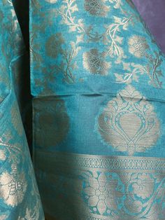 Stunning Banarasi Dupatta in Pastel Sea BlueColor with Muted Zari Weaving. Floral Design in Jaal with tassles. Give your Outfit a new look with these beauties. ❤️ Item: Dupatta Base color : Pastel Sea Blue Fabric : Soft Semi Silk (Not Pure Silk) Work : Zari Weaved with tassels Length of the Dupatta : 92 inches approx. Width of the dupatta : 35 inches (Approx.) Store Policies - No return or exchange will be accepted for color variations. - No return or exchange will be accepted if the color does not match your other clothing or your partners or anyone else. - Since this Dupatta is handmade hence little inconsistencies may be there however it is not considered as a defect. - Zari or thread coming out or on folds is not considered as defects. - Slight variation in actual color vs. image is po Blue Chanderi Choli With Self Design, Blue Handloom Lehenga For Traditional Ceremonies, Blue Handloom Dupatta For Traditional Ceremonies, Blue Handloom Lehenga For Diwali, Handloom Blue Lehenga For Diwali, Blue Choli With Dupatta For Puja, Blue Raw Silk Dupatta With Self Design, Handloom Blue Dupatta For Traditional Ceremonies, Blue Self-design Choli For Puja