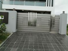 an entrance to a modern house with grey walls and metal gates on the front door