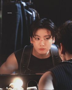 a man is looking at his reflection in the mirror while another person looks into it