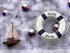 a life preserver, boat and christmas ornaments on a white furnishing background