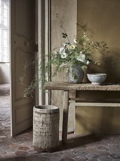 a vase filled with flowers sitting on top of a table next to a wooden bench