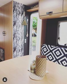 the interior of a camper with wood furniture and decorative wallpaper on the walls