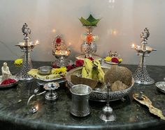 a table topped with lots of silver dishes filled with food and candles on top of it