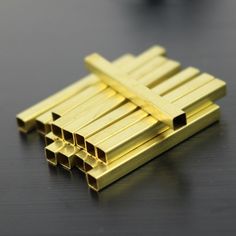 several gold colored metal bars on a black surface with one piece missing from the top