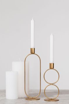 three candles are sitting next to each other on a table with one candle in the middle