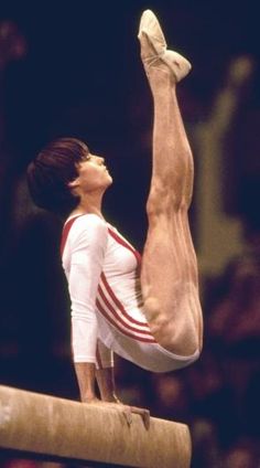 a man on the balance beam doing a handstand