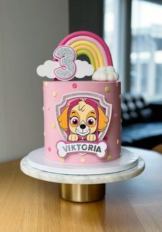 a pink birthday cake with a cartoon dog on the front and number three on the back