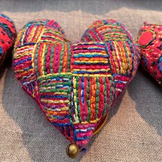 two colorful heart shaped cushions sitting on top of a couch