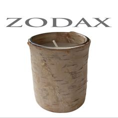 a candle that is sitting inside of a wooden container with the word zodax on it