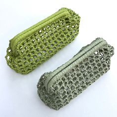 two crocheted bags sitting next to each other on a white surface with no one around them