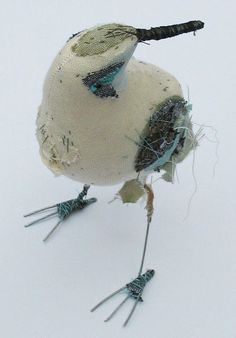 an odd looking bird made out of something white and blue with black feathers on it's legs