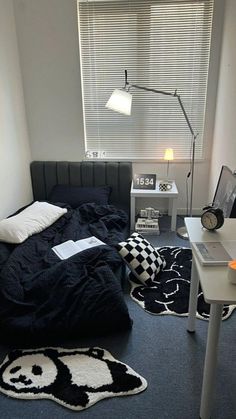 a bedroom with a bed, desk and lamp