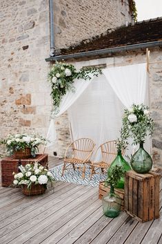 an outdoor wedding setup with flowers and greenery on the back deck at this rustic venue