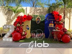 the balloon arch is decorated with red, gold and white balloons