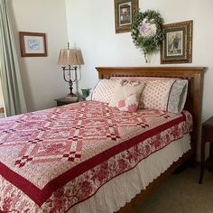 a bed with a red and white bedspread in a bedroom next to a window