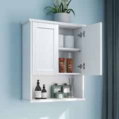 a bathroom with blue walls and white cupboards on the wall next to toiletries