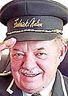 an older man in uniform saluting for the camera with his hand on his head