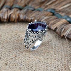 Elevate your style with our Handcrafted Sterling Silver Dome Cocktail Ring, a true masterpiece of filigree artistry. Meticulously crafted from 925 sterling silver, this ring exudes timeless elegance. Adorned with a mesmerizing 13x18 mm cabochon or faceted oval cut gemstone, you have the choice of the enchanting Rhodonite, the captivating Purple Mohave Turquoise, or the regal Amethyst. The ring face length is 0.80 inches and the width is 0.60 inches  Each gemstone tells a unique story: Rhodonite symbolizes love and compassion, Purple Mohave Turquoise represents balance and tranquility, and Amethyst embodies peace and clarity. With 16 different sizes available, ranging from a delicate size 5 to a bold 12.5, including half sizes, finding the perfect fit is effortless. Celebrate life's special Bohemian Oval Jewelry With Accent Stones, Bohemian Sterling Silver Jewelry With Accent Stones, Sterling Silver Filigree Ring With Gemstone, Ornate Sterling Silver Amethyst Gemstone Ring, Ornate Sterling Silver Amethyst Ring, Sterling Silver Ring With Gemstone Accents, Sterling Silver Ring With Large Stone For Wedding, Ornate Amethyst Gemstone Ring, Ornate Ring Jewelry With Accent Stones