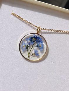 A beautiful and unique Botanical inspired terrarium necklace with real forget me not flowers. For memories of a close one, for true love and to show someone you will never forget them  💕 The flower is encapsulated in a crystal clear Resin which is Non-toxic, No VOCs, No fumes, No solvents, Non-flammable, Non-hazardous, No BPA.  The necklace chain is gold plated solid brass or stamped 14k gold filled chain as shown in last photo. This chain is much more long lasting and delicate. (this one is sh Dainty 14k Gold Filled Birth Flower Necklace, 14k Gold Filled Birth Flower Pendant Jewelry, 14k Gold Filled Round Birth Flower Jewelry, Gold Botanical Flower Pendant Jewelry, Delicate 14k Gold Filled Jewelry With Flower Charm, Delicate 14k Gold-filled Jewelry With Flower Charm, 14k Gold Filled Flower Pendant Jewelry Gift, 14k Gold Filled Birth Flower Pendant Necklace, 14k Gold Filled Birth Flower Necklace