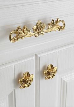 a white cabinet with gold handles and knobs