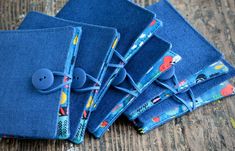 four blue cloths with buttons on them sitting next to each other in front of a wooden table