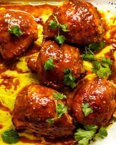 meatballs covered in sauce and garnished with cilantro