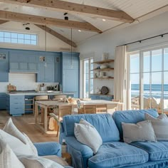 a living room filled with furniture next to a kitchen