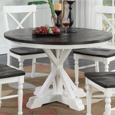 a dining table with four chairs and a vase filled with flowers on top of it