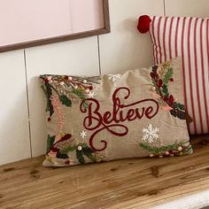 two decorative pillows sitting on top of a wooden shelf