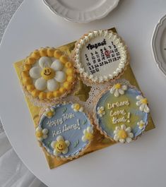 four decorated cookies sitting on top of a table