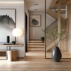 a vase sitting on top of a wooden floor next to a stair case and table