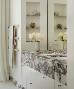 a bathroom with marble counter tops and double sinks